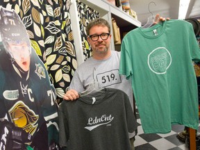 Owner Chris McInnis shows off a trio of London-inspired shirts for sale at his shop, Uber Cool Stuff, for those Londoners looking to show off their local pride as the city hosts the Memorial Cup. (CRAIG GLOVER, The London Free Press)