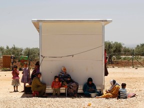 Syrian refugees rest in the shade of their makeshift home at a Syrian refugee camp north of Aleppo beside the Syrian-Turkish border May 17, 2014. REUTERS/Jalal Al-Mamo