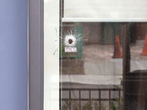 A Regent Park townhouse was riddled with gunfire early Sunday but nobody was hurt. Cops labelled five "impact" points on the home's front door, window and wall. (CHRIS DOUCETTE/Toronto Sun)