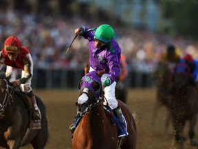 California Chrome #3, ridden by Victor Espinoza, crosses the finish line to win the 139th running of the Preakness Stakes at Pimlico Race Course on May 17, 2014 in Baltimore, Maryland. (Matthew Stockman/Getty Images/AFP)