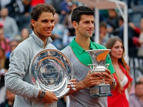 Second-placed Rafael Nadal (L) of Spain and first-placed Novak Djokovic of Serbia pose with their trophies after the men's singles final match at the Rome Masters tennis tournament May 18, 2014. (REUTERS)