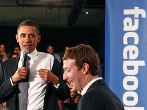 U.S. President Barack Obama takes off his jacket as he attends a town hall meeting at Facebook headquarters with CEO Mark Zuckerberg in Palo Alto, April 20, 2011.  (REUTERS/Jim Young)