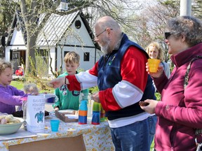 Lilah, Adele and Noah Booth sell lemonade, brownies and cookies to neighbours John and Heather Schreiner on Saturday to help raise money for Turtles Kingston and fencing that will help save the local turtle population. Julia McKay/The Whig-Standard