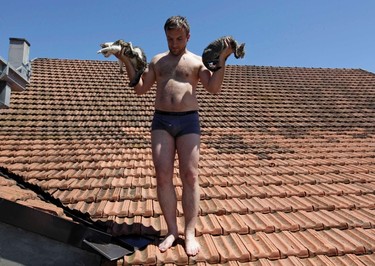 A man rescues cats from the roof during heavy floods in Vojskova May 19, 2014. More than a quarter of Bosnia's four million people have been affected by the worst floods to hit the Balkans in more than a century, the government said on Monday, warning of "terrifying" destruction comparable to the country's 1992-95 war. REUTERS/Srdjan Zivulovic