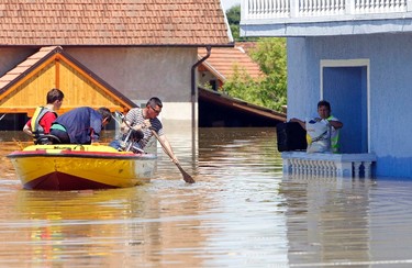 A man waits to be rescued from his house during heavy floods in Vojskova, May 19, 2014. More than a quarter of Bosnia's four million people have been affected by the worst floods to hit the Balkans in more than a century, the government said on Monday, warning of "terrifying" destruction comparable to the country's 1992-95 war. REUTERS/Srdjan Zivulovic