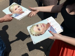 A supporter of Ukrainian presidential candidate Yulia Tymoshenko gives out calendars with her portrait and leaflets during the campaign in the western Ukrainian city of Lviv on May 19, 2014. AFP PHOTO/ YURIY DYACHYSHYN