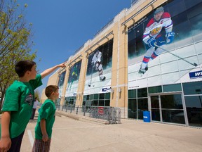 Jacob Martin, 8 and his little brother Mason, 5, look at the huge posters of the captains of the four teams playing in the Memorial Cup in London, Ont. on Monday May 19, 2014. At right is Edmonton Oil Kings' captain Griffen Reinhart. (Mike Hensen, The London Free Press)