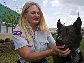 Canada Post carrier Pam Horne poses with Dexter, a shepherd-collie, during a media event raising the issue of dog bite prevention at the Animal Care and Control Centre in Edmonton on Tuesday. (CODIE MCLACHLAN/Edmonton Sun)