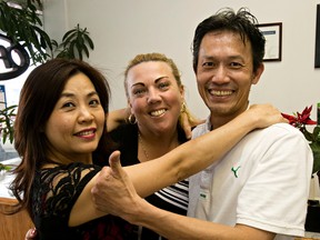 Sasha Partington, centre, poses with Lien Nguyen, left, and her husband, Vu Nguyen, at Kensington Cleaners in Edmonton on Tuesday. (CODIE MCLACHLAN/Edmonton Sun)