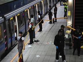 Crime scene investigators walk at the scene of a knife attack at a subway platform in the Taipei Metro Jiangzicui station in New Taipei city May 21, 2014. (REUTERS/Stringer)