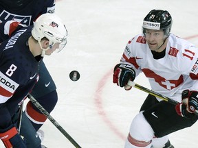 Winnipeg Jet and Team USA defenceman Jacob Trouba (left) fights for the puck with Switzerland's forward Benjamin Pluss during a world hockey championship tournament game last week. Trouba has a neck strain and has been returned to Winnipeg. (AFP PHOTO/ALEXANDER NEMENOV)