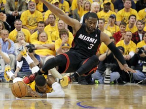 Indiana Pacers forward Paul George (24) gets hit in the head by Miami Heat guard Dwayne Wade (3) during a scramble for a loose ball in game two of the Eastern Conference Finals of the 2014 NBA Playoffs at Bankers Life Fieldhouse. (Brian Spurlock-USA TODAY Sports)