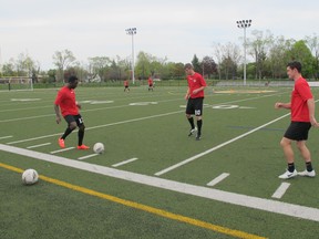 Kingston FC players, from left, Jinmi Ismail of Nigeria, Stephen Hindmarch of England and Fergus Neil of New Zealand work out at Queen's University's West Campus field on Tuesday. (Nick Faris/For The Whig-Standard)