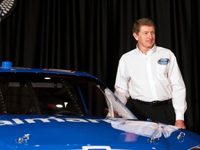 NASCAR driver Bill Elliott poses for photographs in front of the Wal-Mart sponsored car, which he will drive in July at Daytona, during the NASCAR Media Tour in Concord, N.C. January 26, 2012. (REUTERS/Chris Keane)
