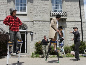 Volunteer Galen Watts, left, SALON actor Patrick Downes and SirJohnA2015 production manager Chantel Martin get lessons on how to walk in stilt from Shadowland Theatre stilt meister Rick Simon, right, outside St. Andrew's Manse on Saturday as part of the giant puppet pageant workshops put on by the Sir John A. Macdonald Bicentennial Commission. Julia McKay/The Whig-Standard
