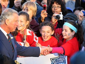 Prince Charles clasps the hand of a member of the St. Charles Force soccer team as he and Camilla, Duchess of Cornwall, met with the public on the Manitoba Legislative grounds on Wed., May 21, 2014, before wrapping their four-day visit to Canada. Kevin King/Winnipeg Sun/QMI Agency