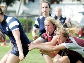 MARK MALONE/The Daily News
Ursuline Lancers' Summer Eastcott, left, is grabbed by Wallaceburg Tartans' Ashlyn Dolbear, centre, and Marissa Dykema during the second half of the Kent girls rugby final Wednesday at Ursuline.