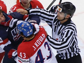 Justin Abdelkader of the U.S. (L) fights with the Czech Republic's Jan Kovar (C) during their men's ice hockey World Championship quarterfinal game at Chizhovka Arena in Minsk May 22, 2014. (REUTERS/Vasily Fedosenko)