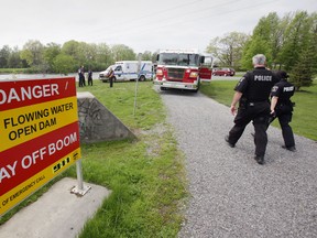 Members of Belleville Fire Department and Belleville Police are seen along the Moira River at Riverside Park, across from the Quinte Sports and Wellness Centre on Cannifton Road in Belleville, Ont., shortly after two teenage girls were rescued from the river. - JEROME LESSARD/THE INTELLIGENCER/QMI AGENCY