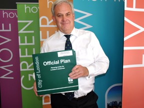 Gregg Barrett, manager of long range planning and research for the City of London, holds a copy of the 1989 official plan at the planning department offices on Dundas Street May 13, 2014. The city’s newest official plan, which includes input from the ReThink London process, is available for public consultation after being unveiled to city council May 22. CHRIS MONTANINI\LONDONER\QMI AGENCY