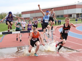 Lasalle's Liam Passi (right) is the first one out of the water pit during the open boys 2,000 metre steeplechase final at the high school track and field championships at the track at Laurentian University on Thursday. Passi won that race and two more Thursday to earn the senior boys overall aggregate title at the meet. See more photos at www.thesudburystar.com