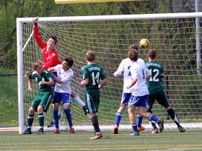 Kingston Blues goalkeeper Pierre Boucher can't make the save on Holy Cross Crusaders' Eric Freitas on a corner kick during the Kingston Area Secondary Schools Athletic Association senior boys soccer championship game at Queen's West Campus on Thursday. Holy Cross won 2-0. (IAN MACALPINE /THE  WHIG-STANDARD)