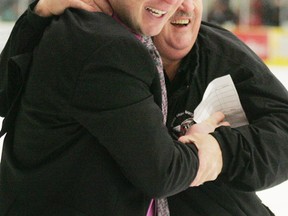 Saints head coach Jason McKee (left) shares a celebratory hug and smile with team trainer Moe Laplante after the Saints captured the AJHL championship trophy for this year in Drumheller with a 2-1 overtime win. - Gord Montgomery, Reporter/Examiner