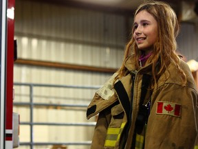 Grade 5 student, Mercedes Torgersen, tries on some bunker gear at the fire safety station during ADM and the Progressive Agricultural Foundation's Progressive Agriculture Safety Days held at Lakeland College on May 20.