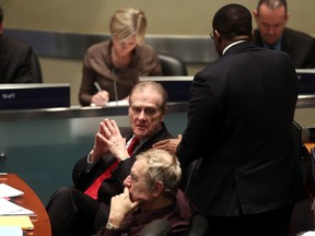 Deputy Mayor Norm Kelly is congratulated by Councillor Michael Thompson after his budget motion won at a special meeting of Toronto city council to deal with the 2014 budget in this file photo from Jan. 29, 2014. (MICHAEL PEAKE/Toronto Sun)