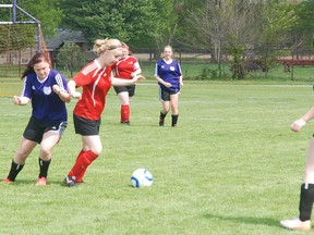 West Elgin Wildcasts Kim Bandeen, left moves in to defend an Arthur Voaden Vikings player in a playoff game last week in West Lorne. Helping her out is Whitney Small, right. In the background is Tina Lettner also of WESS. West Elgin won 7-0.
