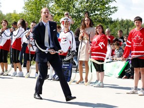 Britain's Prince William and his wife Catherine, the Duchess of Cambridge, react after the prince took a shot with a hockey stick and missed during a visit to the Somba K'e Civic Plaza in Yellowknife, NWT, on July 5, 2011. (REUTERS files)