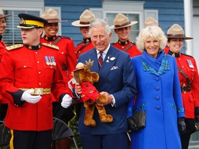 Britain's Prince Charles holds a stuffed toy moose beside his wife Camilla, Duchess of Cornwall and RCMP officers in Pictou, Nova Scotia, May 19, 2014.   REUTERS/Mark Blinch