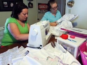 Sherie Vukelic and her mother in-law Donna Koop work on turning donated wedding dresses into burial gowns for grieving parents. (DAVE THOMAS/Toronto Sun)