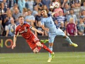 Toronto FC defender Steven Caldwell heads the ball away from Sporting KC forward Dominic Dwyer on Friday night. (USA TODAY/PHOTO)