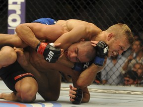 Renan Barao (red) struggles to break free of T.J. Dillashaw's choke hold during their UFC 173 bantamweight championship bout at MGM Grand Garden Arena. (Stephen R. Sylvanie/USA TODAY Sports)