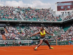 Serena Williams of the U.S hits a return to Alize Lim of France, during their women's singles match at the French Open tennis tournament at the Roland Garros stadium in Paris May 25, 2014.            REUTERS/Jean-Paul Pelissier