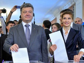 Ukrainian businessman, politician and presidential candidate Petro Poroshenko (L front) and his wife Maryna (R front), cast their votes during a presidential election at a polling station in Kiev May 25, 2014.   REUTERS/Mykola Lazarenko/Pool