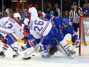 Rangers’ Rick Nash (right) crashes into goalie Dustin Tokarski (rear) after being tied up by defenceman Josh Gorges on Sunday night at Madison Square Garden. The collision riled up Habs coach Michel Therrien, who’s already lost one netminder. (USA TODAY/SPORTS)