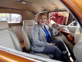 Andrea Horwath, NDP leader, laughs as Don Carter hands her the keys so she can fire up his 1935 Dodge coupe during Horwath's tour of RetroFest in Chatham, Ont., May 24, 2014. (Diana Martin/QMI Agency)