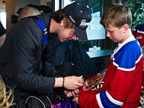 Edmonton Oil Kings’ Edgars Kulda signs an autograph at the Shell Aerocentre at the Edmonton International Airport on Monday. The Oil Kings returned from London, Ont. after winning the 2014 Memorial Cup on Sunday. (CODIE MCLACHLAN/EDMONTON SUN)