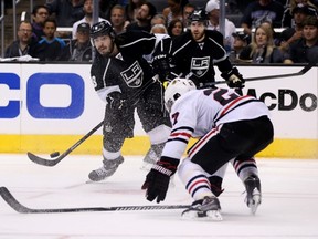Kings’ Drew Doughty takes a shot while Blackhawks’ Johnny Oduya tries to block it during Game 4 on Monday night in Los Angeles. (AFP)