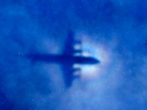 The shadow of a Royal New Zealand Air Force (RNZAF) P3 Orion maritime search aircraft can be seen on low-level clouds as it flies over the southern Indian Ocean looking for missing Malaysian Airlines flight MH370 in this March 31, 2014 file photo. REUTERS/Rob Griffith/Pool/Files