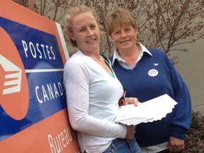 Tammy White and Sue Sitlington, president of the local chapter of the Canadian Union of Postal Workers (CUPW)mail White's wedding invitations at Strathroy's Post office. This month both women denounced the increased cost of stamps.