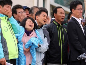 Family members of dead and missing passengers onboard the sunken ferry Sewol, cry at a port in Jindo May 20, 2014.South Korea's legal system appears to be failing 15 surviving crew of a ferry that sank last month, killing hundreds of children, with their being tried and convicted by an angry public before the case has even come to court. (REUTERS/Yonhap)