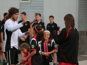 Fury FC striker Tom Heinemann greets young Fury players during an open training session at Algonquin College Tuesday night. (Chris Hofley/Ottawa Sun)​