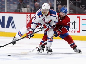Rangers’ Derek Stepan (left) and the Canadiens’ David Desharnais battle for the puck in Montreal last night. (AFP)