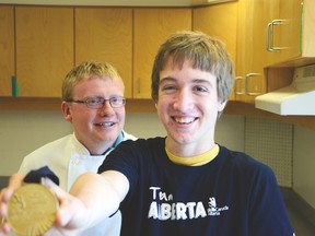 Caelan Taylor, 16, shows off his gold medal from the provincial culinary arts competition and poses with his instructor, Ian Robertson, in the kitchen at Matthew Halton High School.