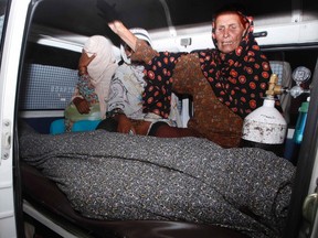 Women mourn over the body of their relative, Farzana Iqbal, who was killed by family members, in an ambulance outside of a morgue in Lahore on May 27, 2014. (REUTERS/Mohsin Raza)