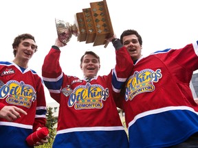 Defenceman Jesse Mills (28), forward Edgars Kulda (23) and forward Brandon Baddock (13) party with the Stafford Smythe Memorial Trophy as the team is celebrated by the City of Edmonton at a downtown parade and street party in Edmonton, Alta., on Wednesday, May 28, 2014. The WHL hockey team beat the Guelph Storm to take the 2014 Memorial Cup. Ian Kucerak/Edmonton Sun/QMI Agency