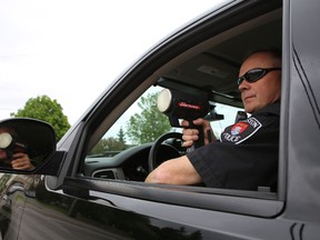 Kingston Police Sgt. Steve Saunders points a radar gun at vehicles on Sydenham Road during Wednesday's city-wide speeding blitz.
ELLIOT FERGUSON/THE WHIG-STANDARD